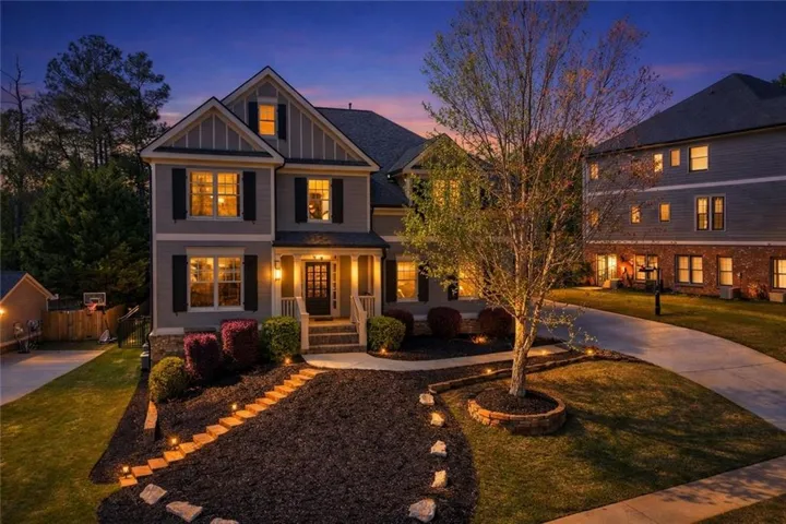 Two-story home with a gabled roof and stone accents, featuring a covered porch and front entry steps