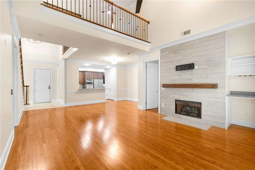 This view toward the entrance foyer and kitchen reflects the spaciousness of the room and provides a glimpse of the open loft area on the second floor.