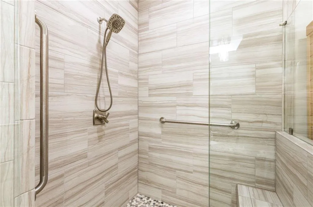 The new, custom oversize shower with 2 glass walls has a built-in bench and grab bars for extra comfort and safety!