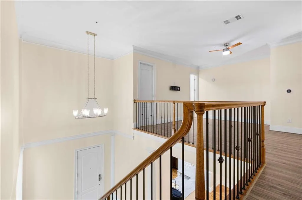 View of the upstairs loft area from the top of the stairs.  The door on the left side is a walk-in closet.  The door in the background is a full bathroom