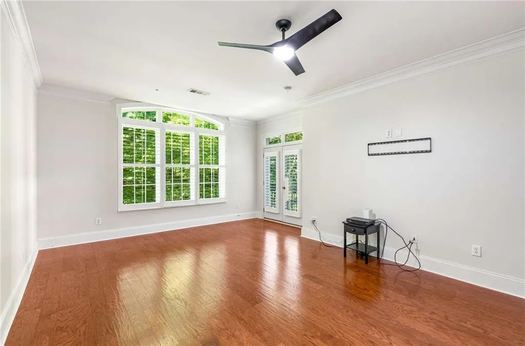 The Primary Bedroom  has a large sitting area and palladian style window system for maximum light and great  woods views.  The French doors open to the large private balcony overlooking the woods of Vinings Mountain.