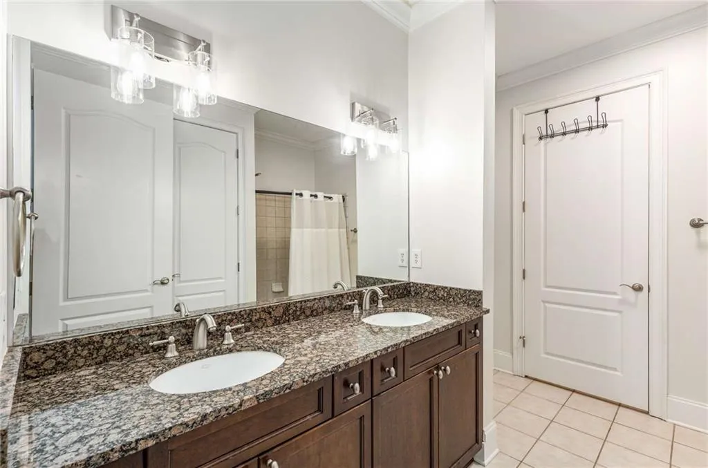 This secondary bathroom has a large vanity with 2 sinks and several drawers and cabinet doors for storage!  The door in the background is for the water closet. The mirror reflects the tub/shower combination.