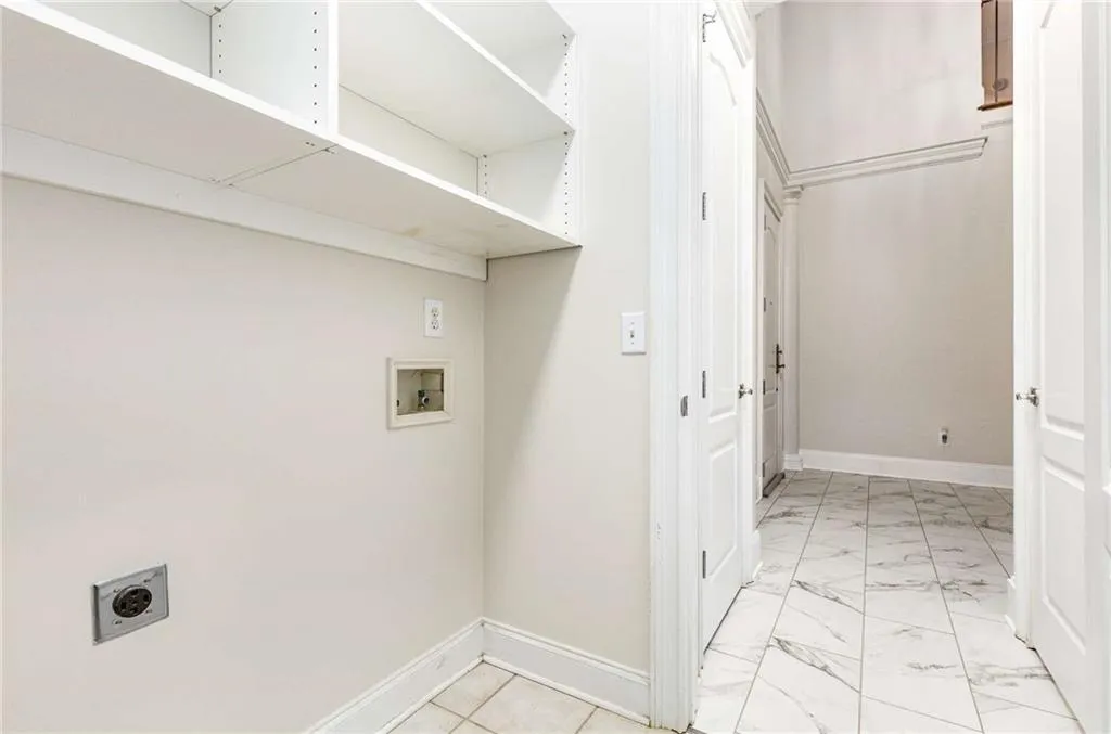 Laundry room in the entrance hallway.  It has shelves, a storage closet and hook-ups for your your washer and electric dryer.  The door to the left in the hallway is the coat closet.  The door on the right opens to the Half Bath/Powder Room.