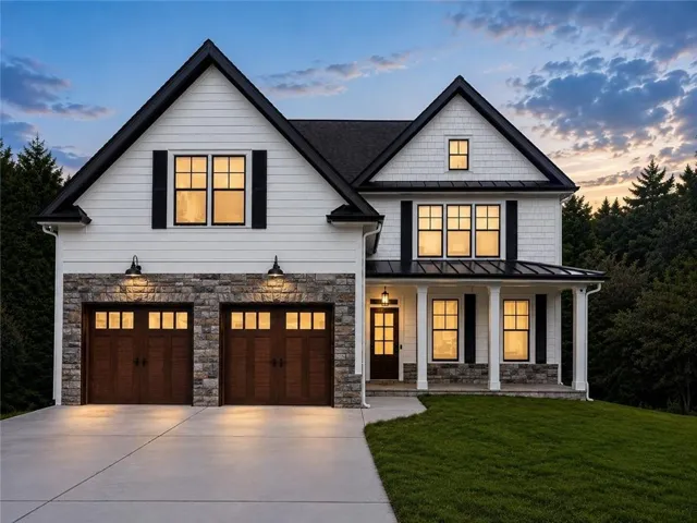 Modern two-story residence featuring a striking white and stone exterior with gabled rooflines and dark architectural accents
