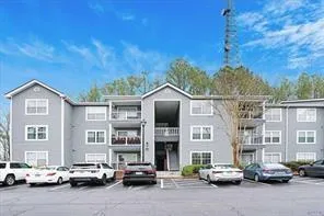 View of apartment building / complex with uncovered parking