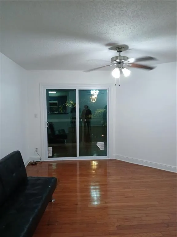 Spare room featuring hardwood / wood-style floors, a textured ceiling, and ceiling fan