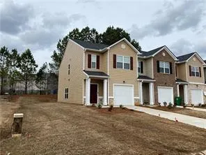 Two-story townhome featuring a neutral siding exterior with dark red shutters, a single-car garage, and a covered entryway