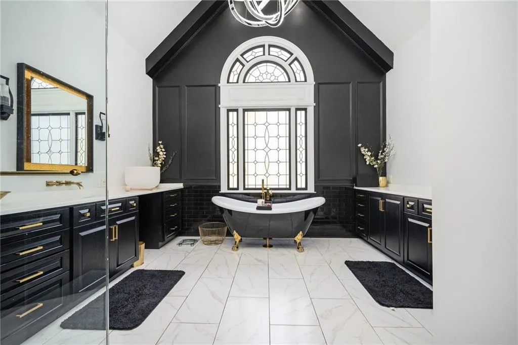Bathroom with a washtub, vanity, and high vaulted ceiling
