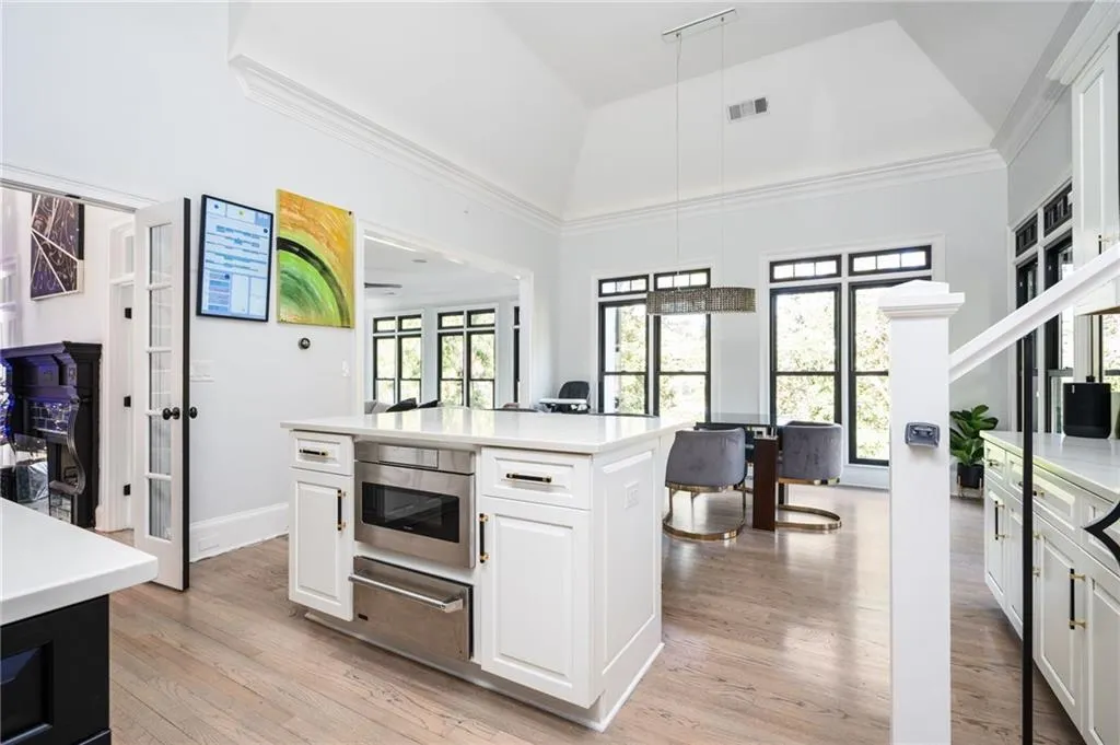 Kitchen featuring pendant lighting, white cabinetry, a kitchen island, and light hardwood / wood-style floors