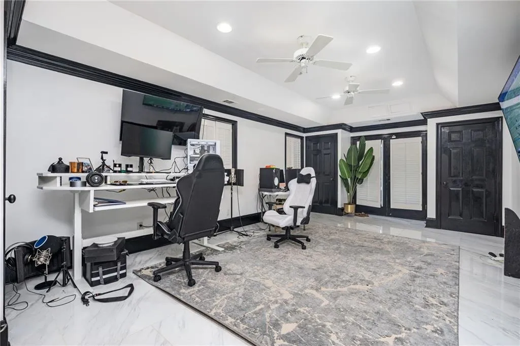 Office featuring a tray ceiling and ceiling fan