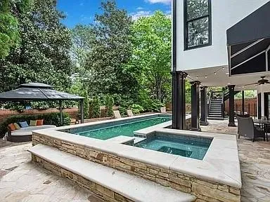 View of swimming pool with stairs, a gazebo, an in ground hot tub, and a patio area
