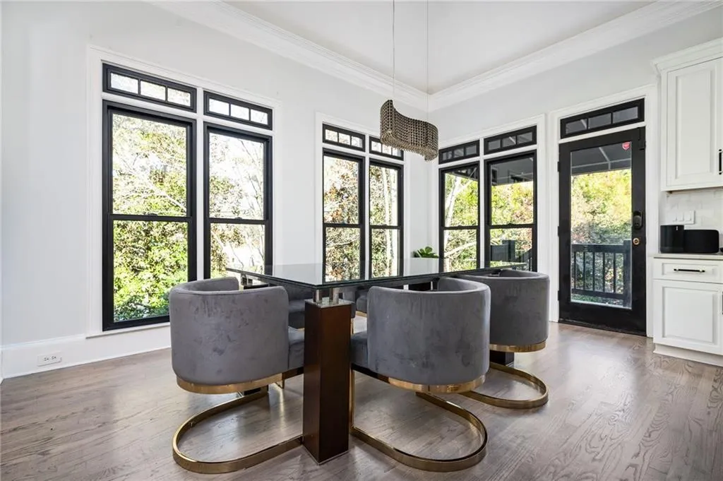 Dining area with a wealth of natural light, dark hardwood / wood-style flooring, and crown molding