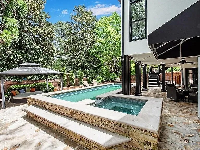 Outdoor pool featuring stairs, a gazebo, an in ground hot tub, and a patio area