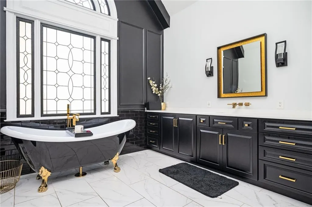 Bathroom with a tub to relax in, tile walls, vanity, and lofted ceiling