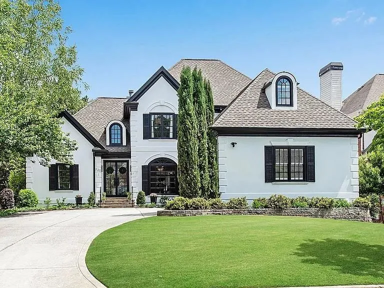 lawn, a shingled roof, and stucco siding