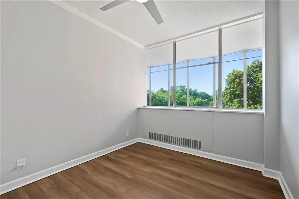 Spare room with wood-type flooring, ceiling fan, a textured ceiling, and crown molding