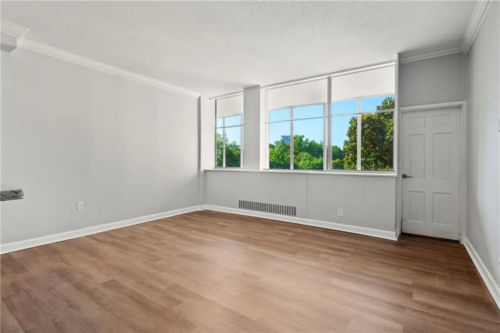 Spare room featuring a textured ceiling, light hardwood / wood-style floors, and ornamental molding