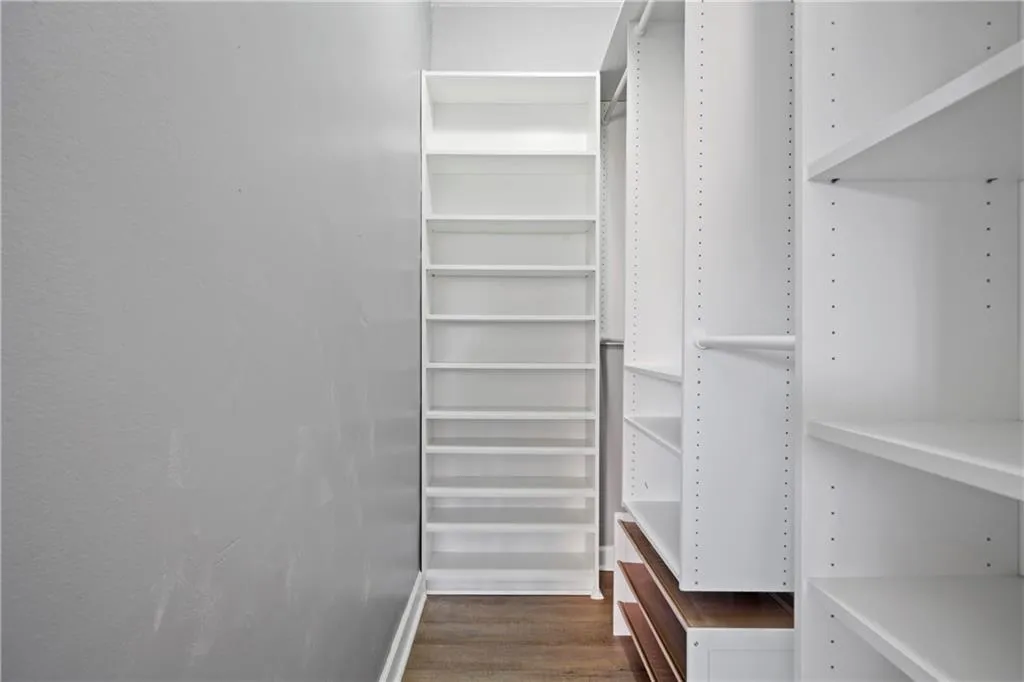 Walk in closet featuring dark wood-type flooring