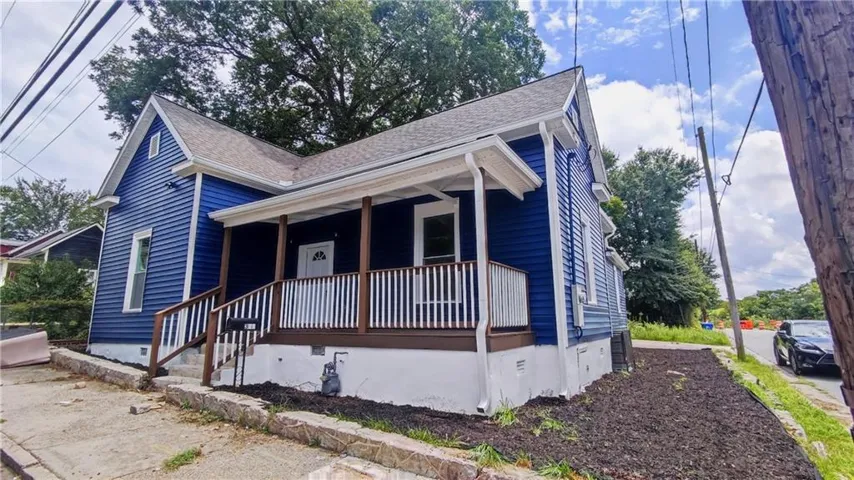 Blue horizontal siding exterior with a covered porch featuring white railings and dark wood-finish posts