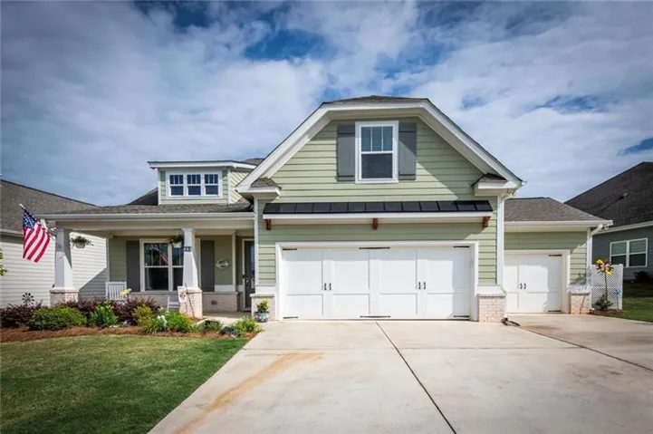 Craftsman-style house with brick siding, covered porch, concrete driveway, a front yard, and a shingled roof