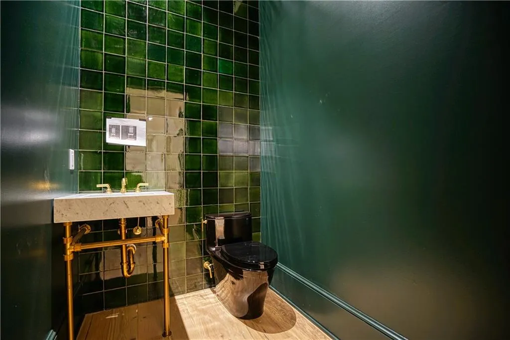 Bathroom featuring tile walls and toilet
