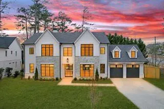 View of front facade featuring a garage and a yard