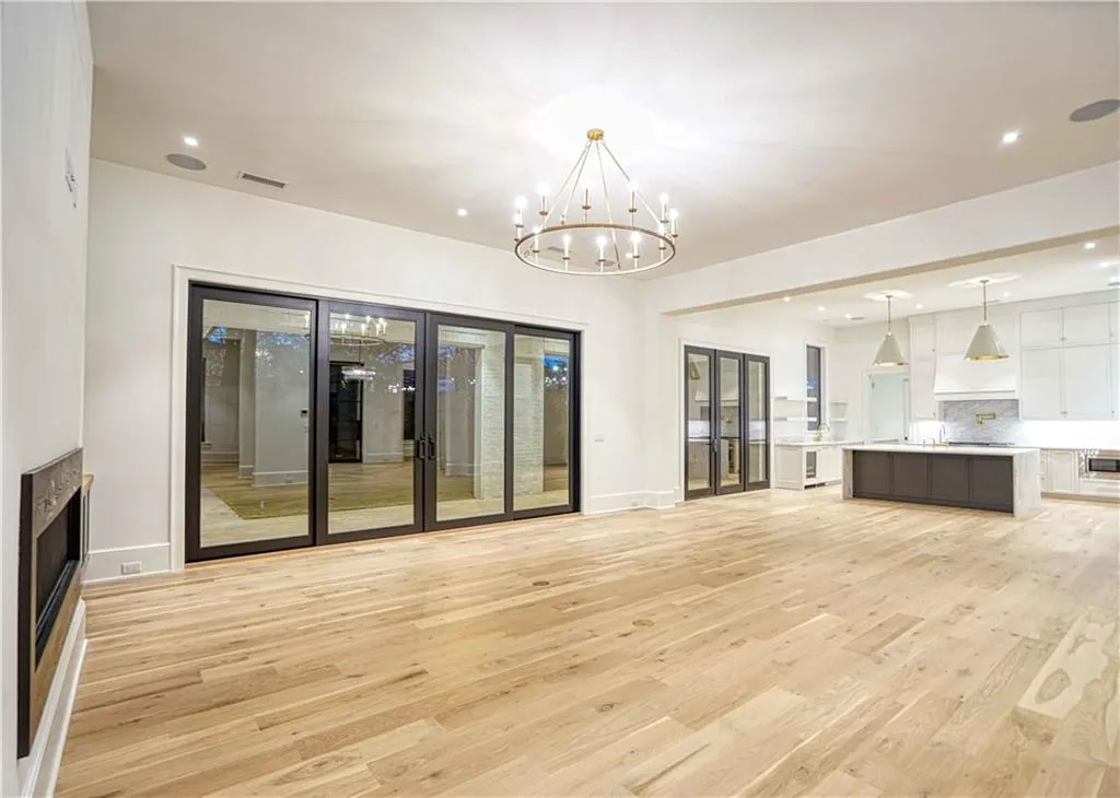 Unfurnished living room featuring a notable chandelier, sink, and light hardwood / wood-style floors