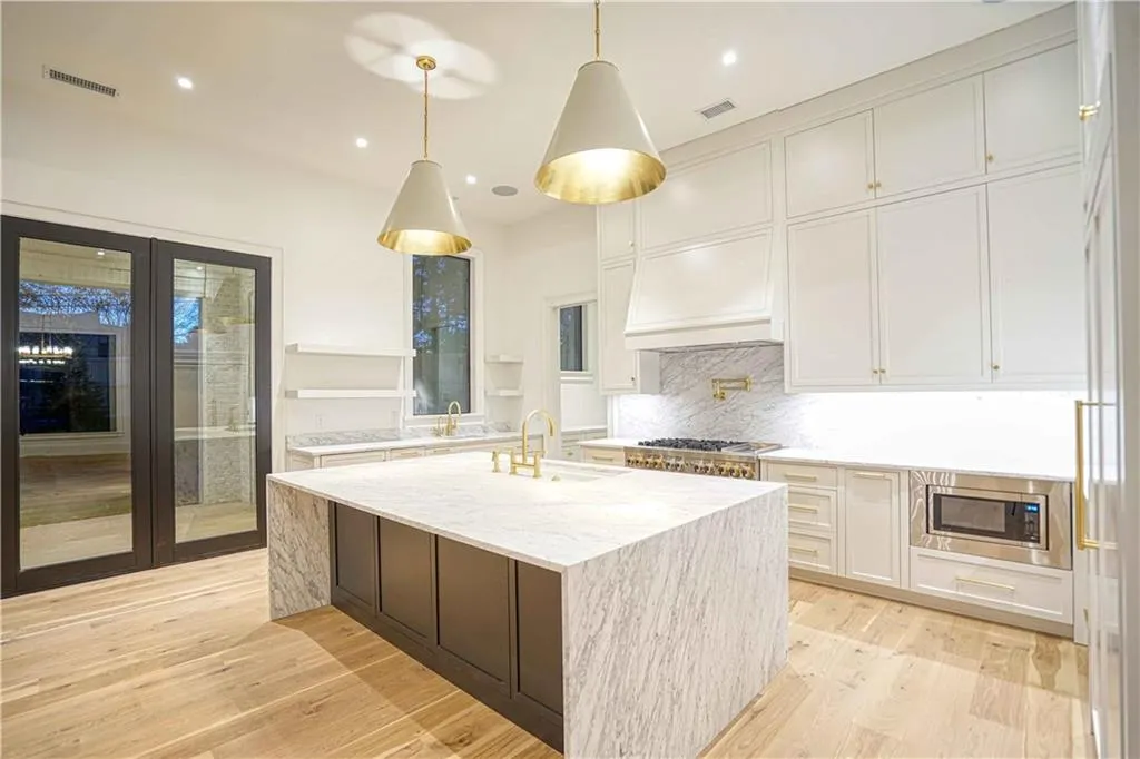 Kitchen featuring light hardwood / wood-style floors, sink, white cabinetry, stainless steel appliances, and light stone countertops