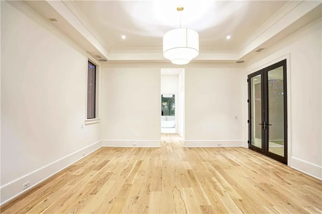 Unfurnished room featuring light wood-type flooring, crown molding, and a tray ceiling