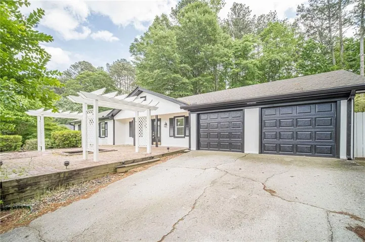 Exterior featuring a white facade, black trim, and a two-car garage with black panel doors