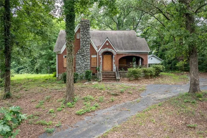 Brick exterior featuring a stone chimney and arched entryway