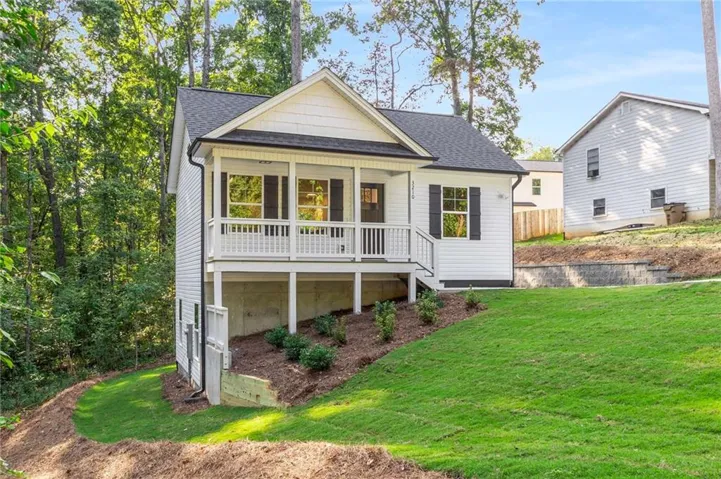 White siding exterior with a dark roof and covered front porch