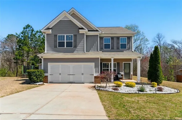 Two-story home with a covered front porch, a two-car garage, and a concrete driveway