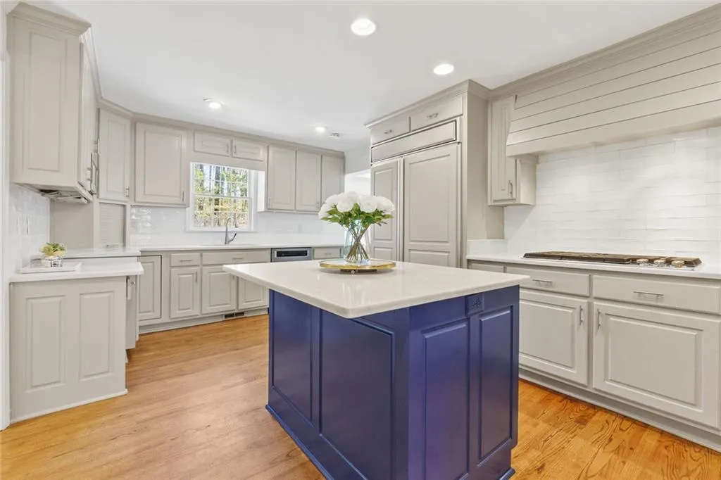 Beautiful Kitchen with Center Island with space for Bar Stools. Quart Countertop and Light Grey Wood Cabinets