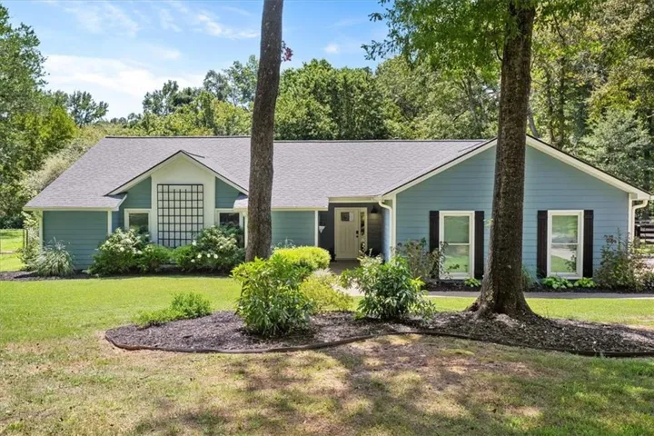 Ranch-style residence featuring blue siding and a gray shingle roof