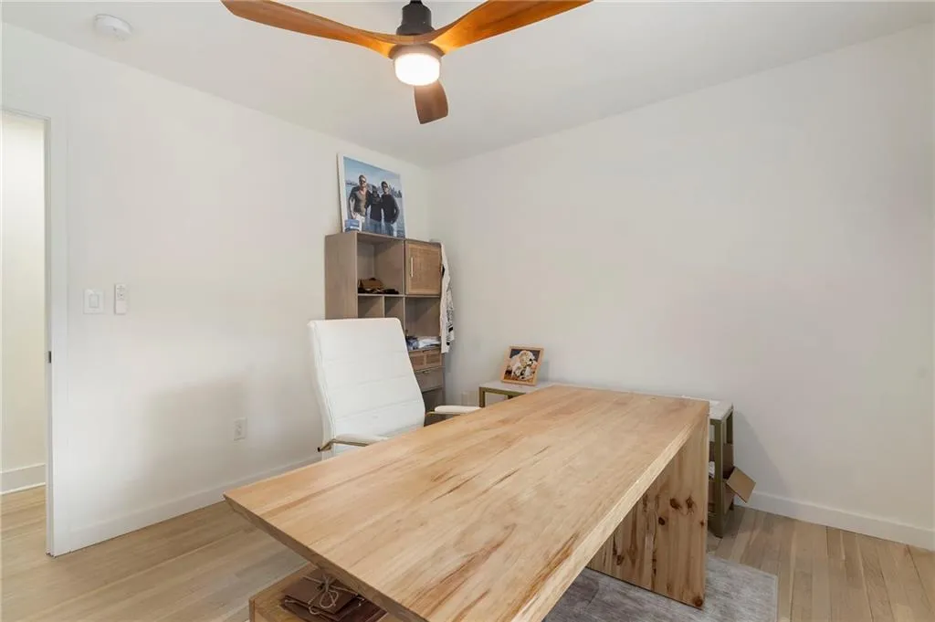 Home office featuring light wood-style flooring and ceiling fan