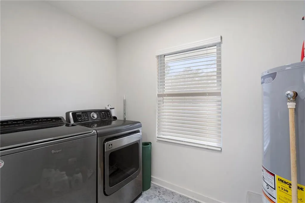 Laundry area with water heater and independent washer and dryer