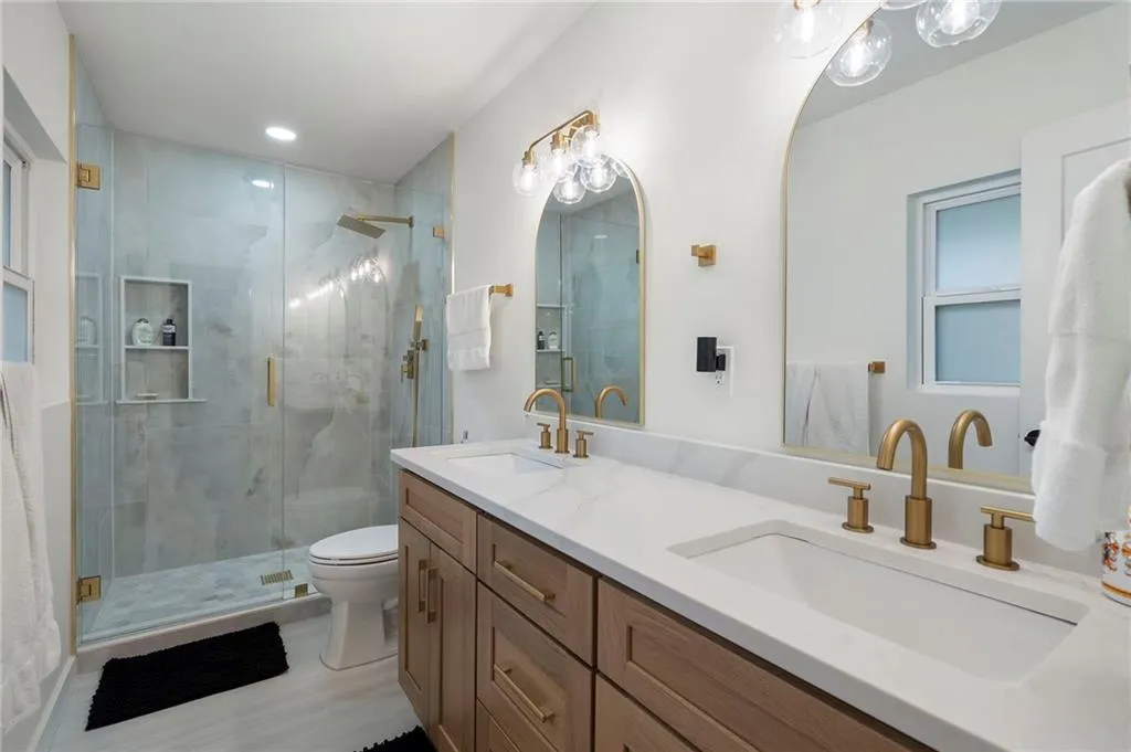 Bathroom featuring double vanity and a shower stall
