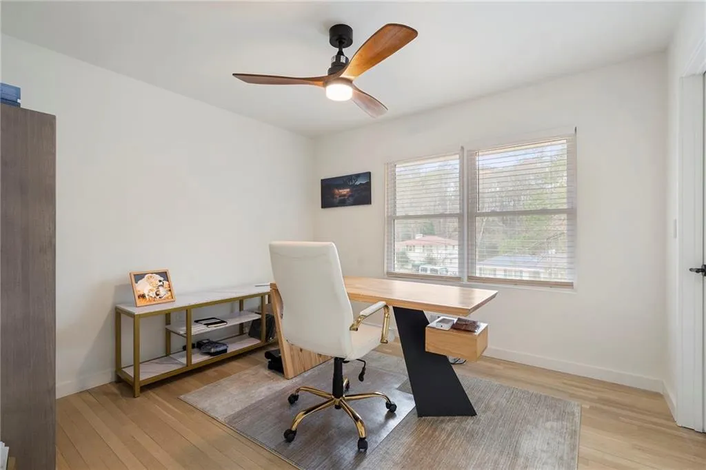 Office area featuring light wood-style floors and ceiling fan