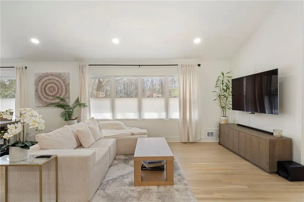 Living room featuring light wood finished floors, lofted ceiling, and recessed lighting