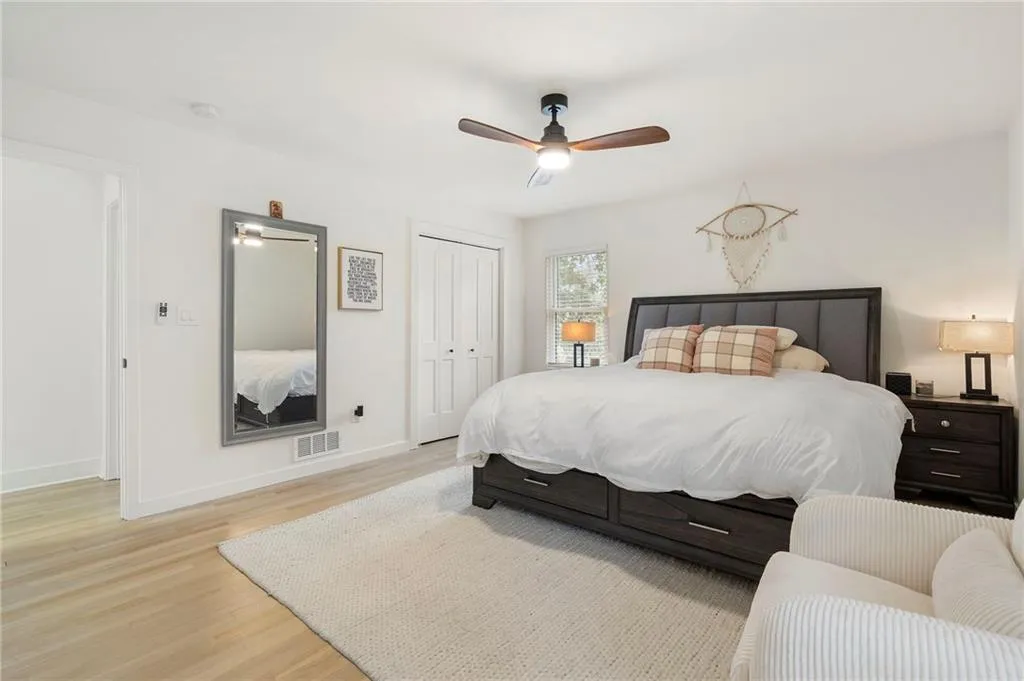 Bedroom with light wood-type flooring, a closet, and ceiling fan