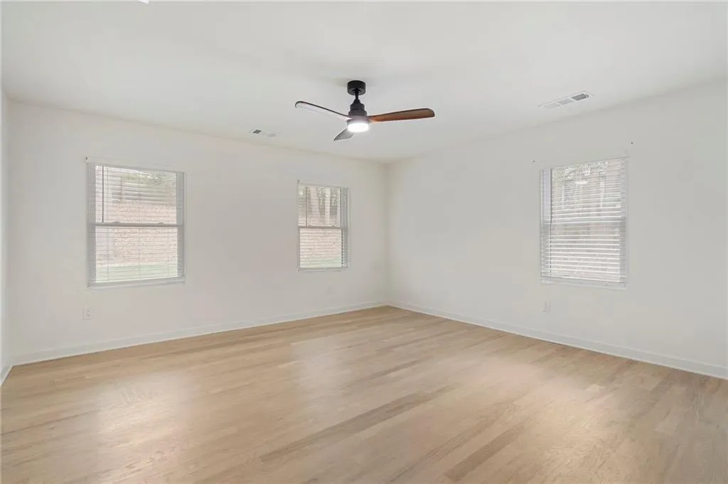Empty room featuring light wood-style floors and a ceiling fan