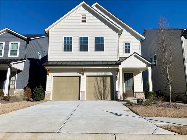 Two-story residence with a light-colored siding exterior, a two-car garage, and a covered front entry