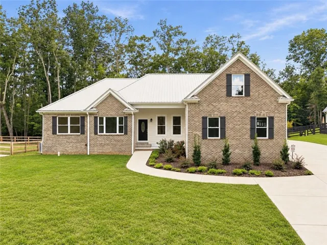 The gorgeous brick, metal roof, and black shutters on this home give it great curb appeal.