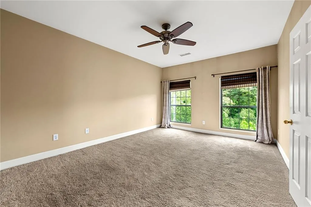 Empty room with carpet and ceiling fan