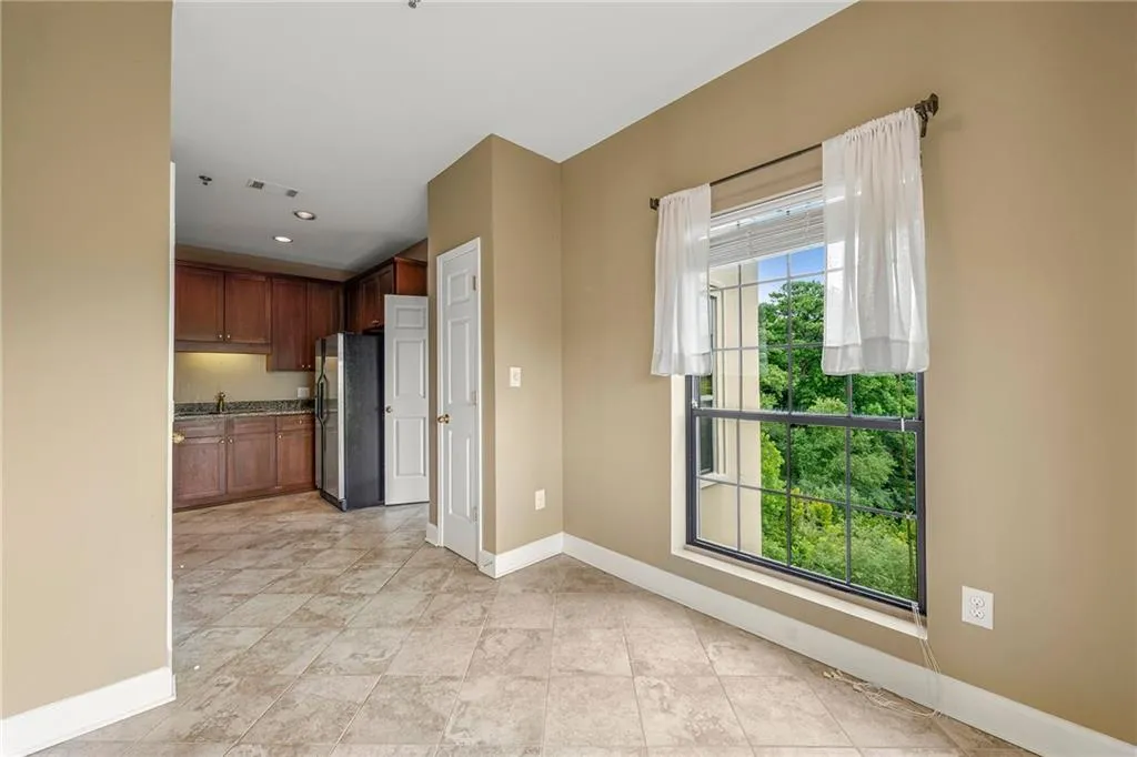 Kitchen with freestanding refrigerator, recessed lighting, brown cabinetry, and light tile patterned flooring