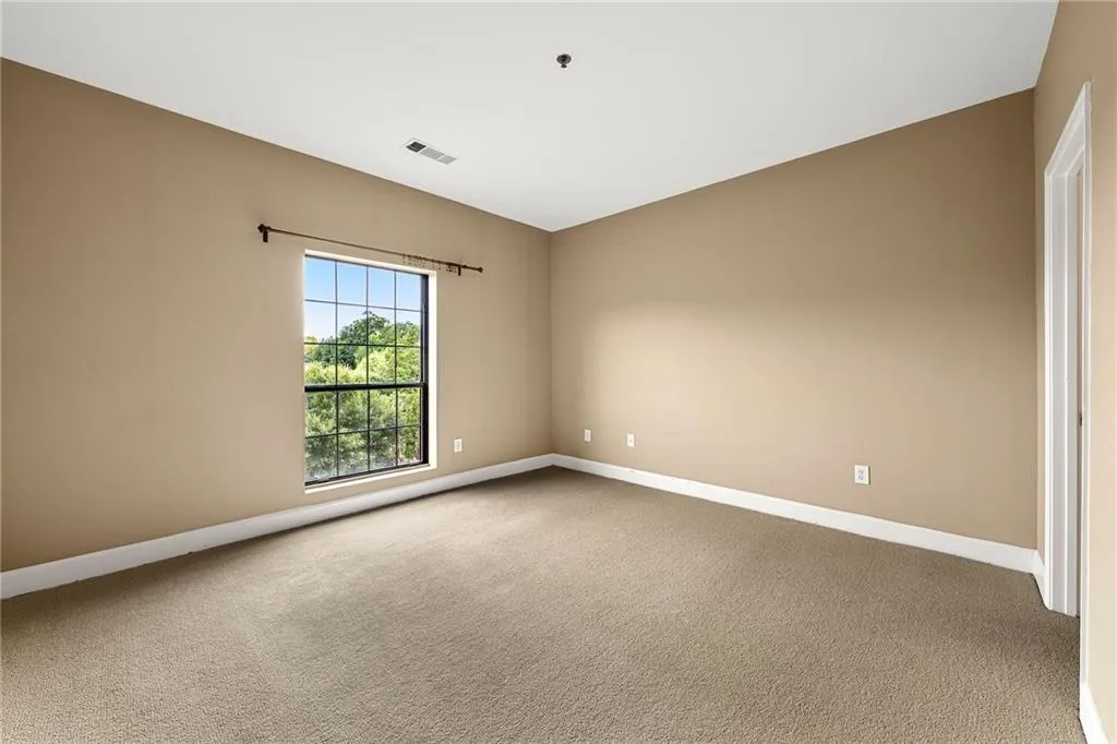 Spare room featuring light colored carpet and baseboards