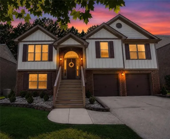 Two-story residence featuring a brick and siding exterior with a welcoming arched entryway