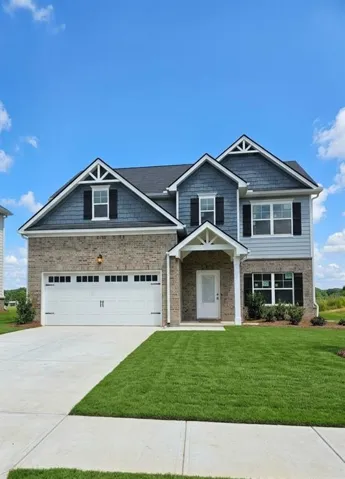 Two-story residence featuring brick and siding facade, covered entry, and attached two-car garage