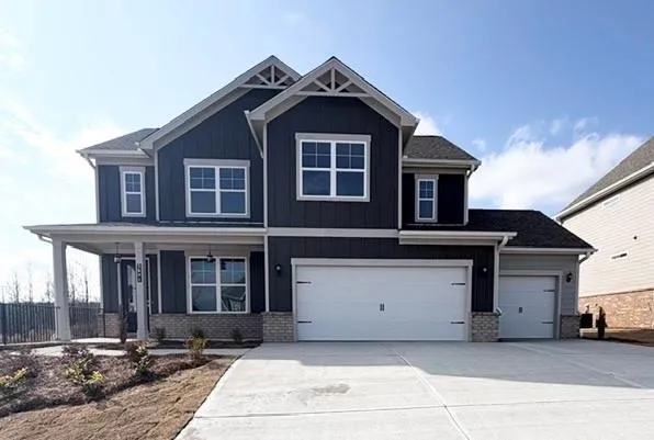 Craftsman-style home with brick siding, a porch, and concrete driveway